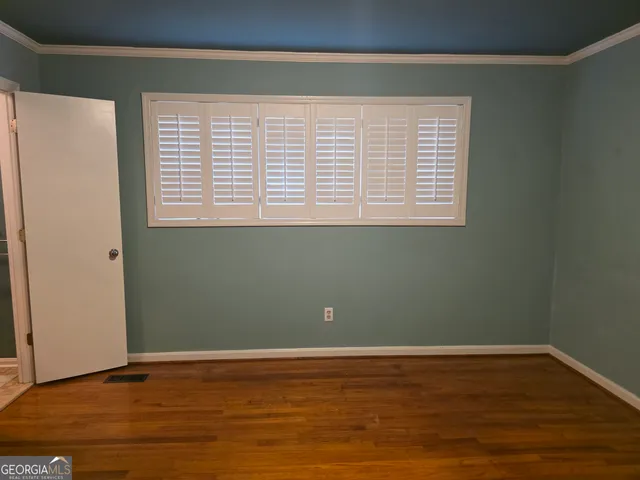 a view of a room with wooden floor and a window