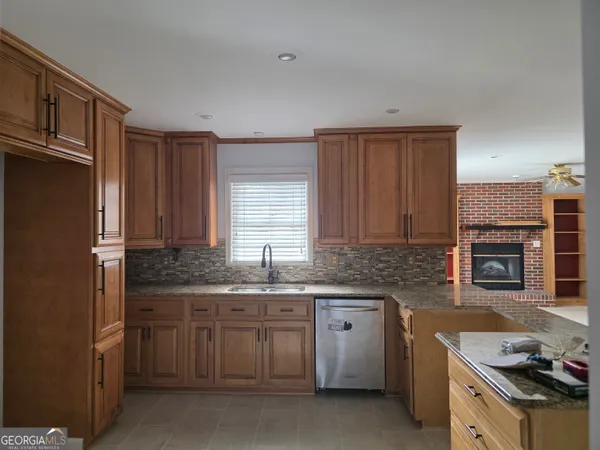a kitchen with stainless steel appliances granite countertop a sink stove refrigerator and cabinets