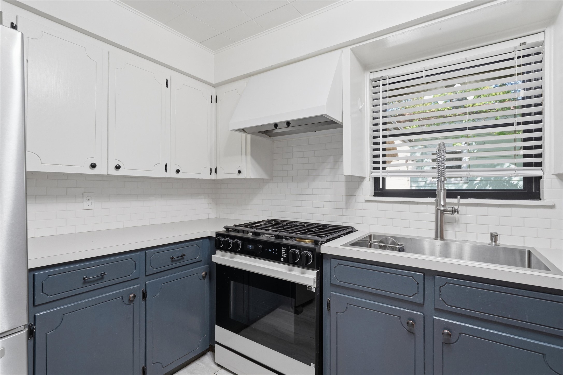 2204 Santa Rita Street Austin, TX 78702 - Photo 9 of 23 Clean white subway tile backsplash complements the solid countertops and classic cabinetry in this workspace.