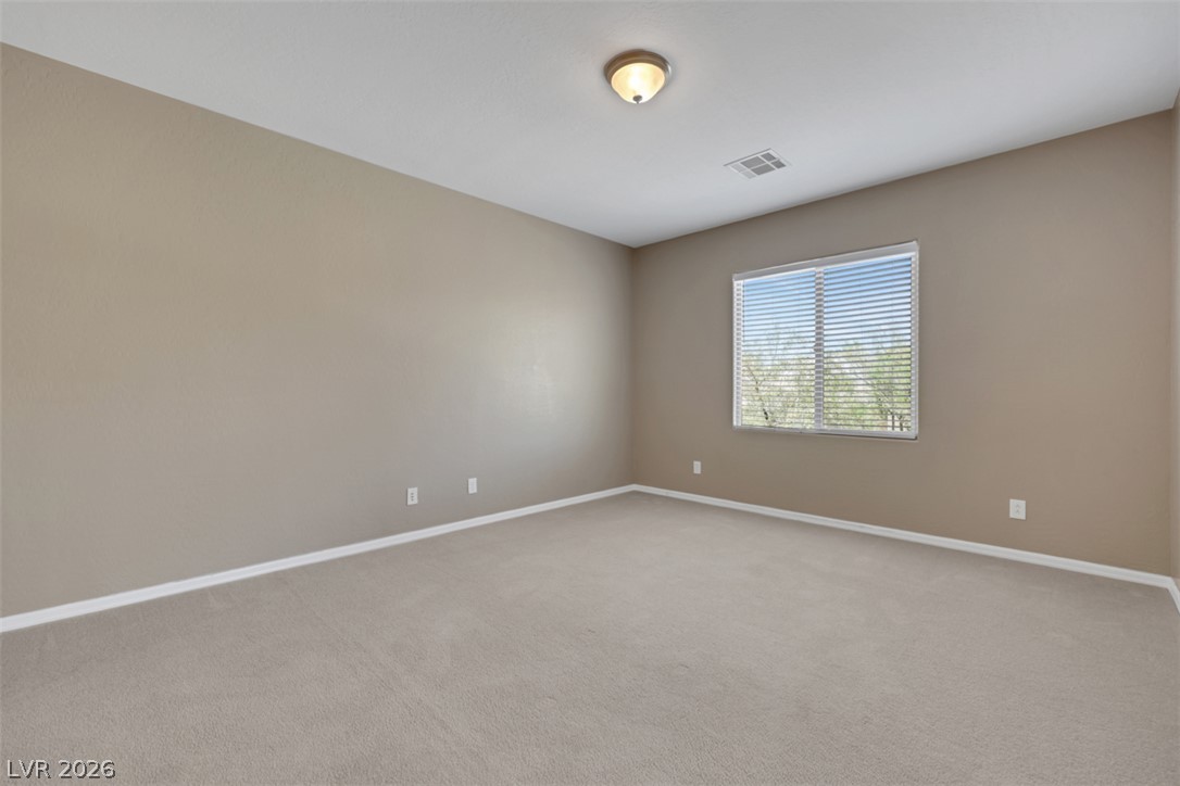 2501 Bechamel Place Henderson, NV 89044 - Photo 24 of 50 A spacious room offers comfortable carpet flooring and a sun-filled window.