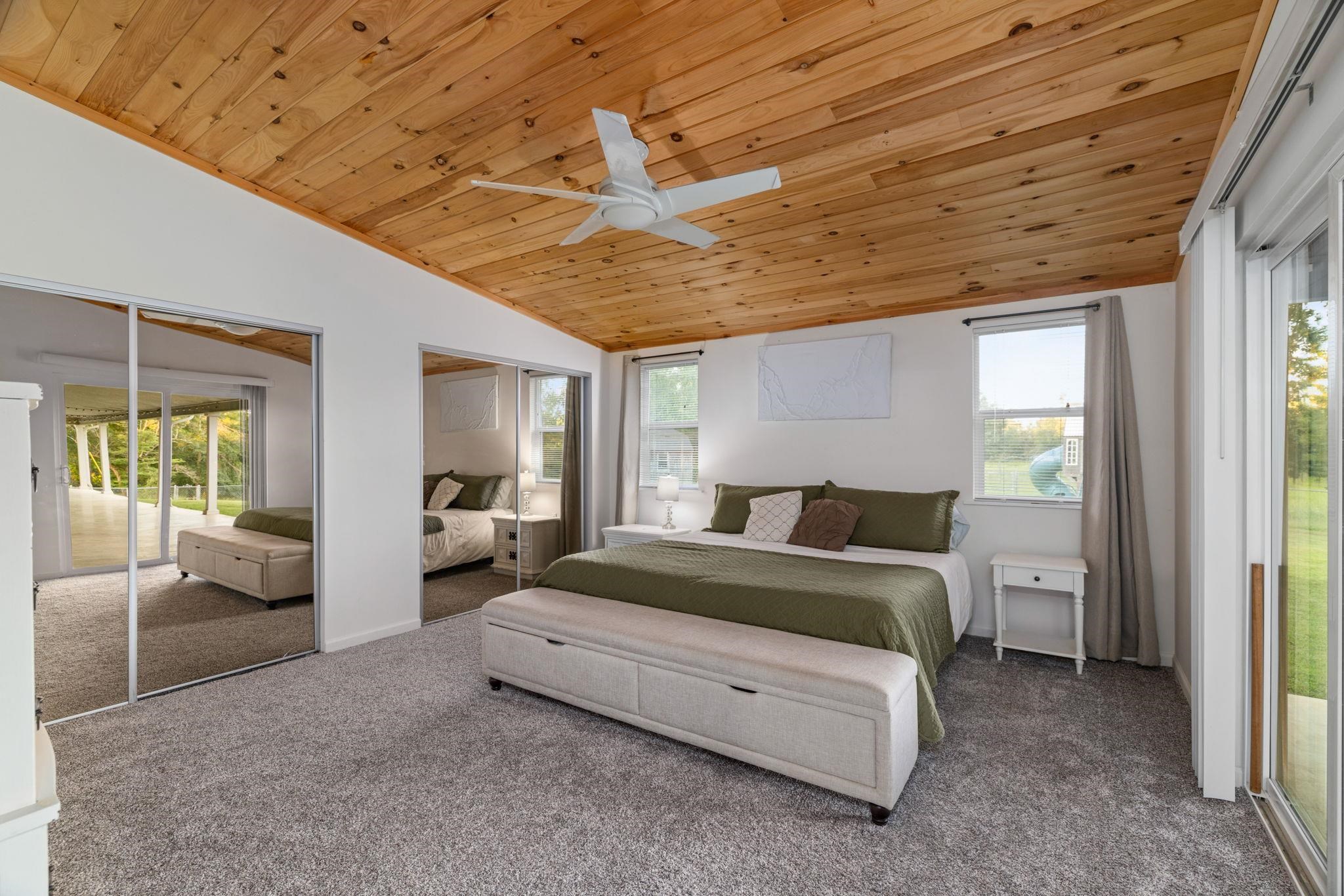 66 County Road 511 Corinth, MS 38834 - Photo 15 of 40 Vaulted wood-plank ceiling with a ceiling fan, plush grey carpeting, white walls, and mirrored closet doors