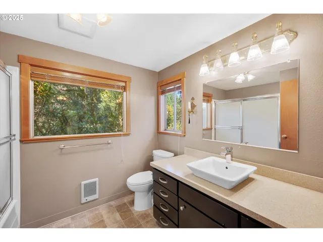 a bathroom with a sink mirror and a toilet