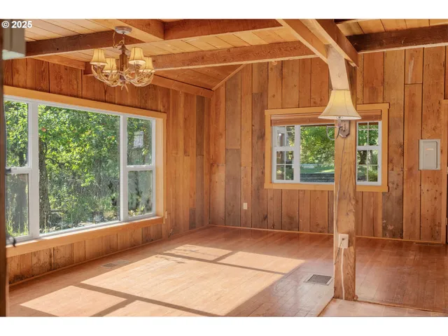 a view of a room with a large window and wooden floor