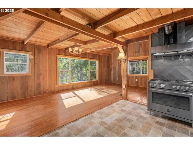 a view of an empty room with a fireplace and a window