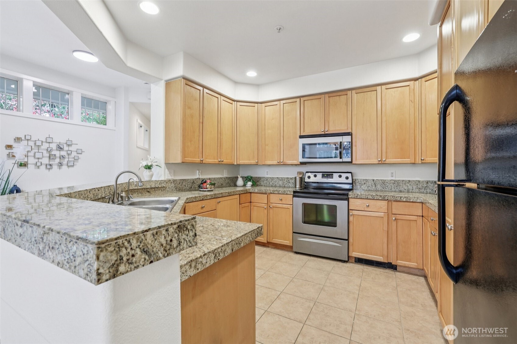 4322 Northeast 5th Court, Unit 105 Renton, WA 98059 - Photo 14 of 36 a kitchen with granite countertop a sink stainless steel appliances and cabinets