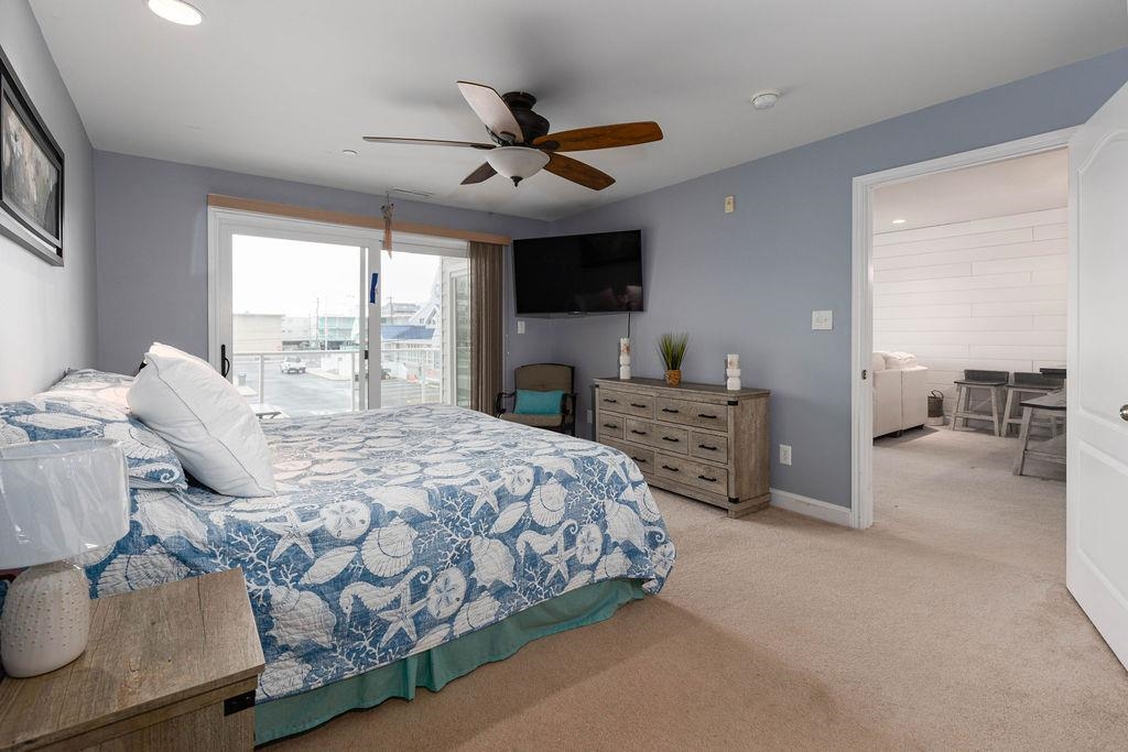 415 East Heather Road, Unit 106 Wildwood Crest, NJ 08260 - Photo 14 of 41 a spacious bedroom with a bed a table and a large window