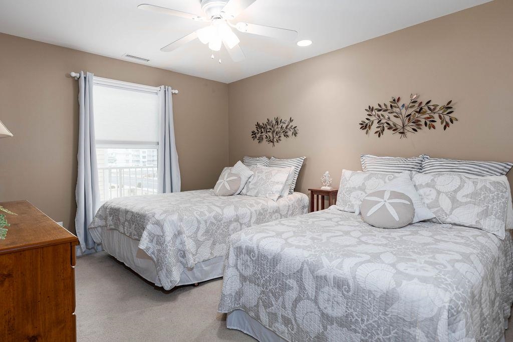 415 East Heather Road, Unit 106 Wildwood Crest, NJ 08260 - Photo 17 of 41 a bedroom with two large bed and a chandelier