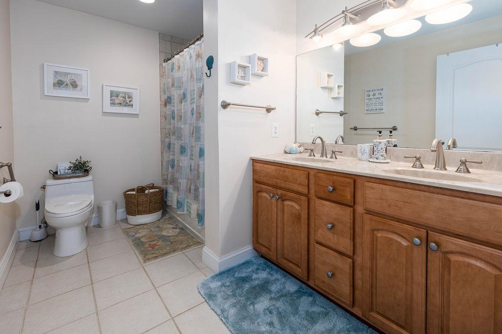 415 East Heather Road, Unit 106 Wildwood Crest, NJ 08260 - Photo 19 of 41 a spacious bathroom with a double vanity sink toilet and a mirror