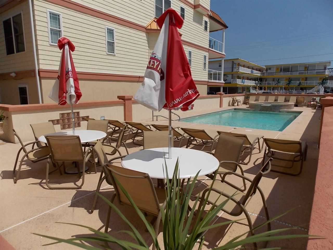 415 East Heather Road, Unit 106 Wildwood Crest, NJ 08260 - Photo 26 of 41 a view of a patio with table and chairs with wooden floor and fence