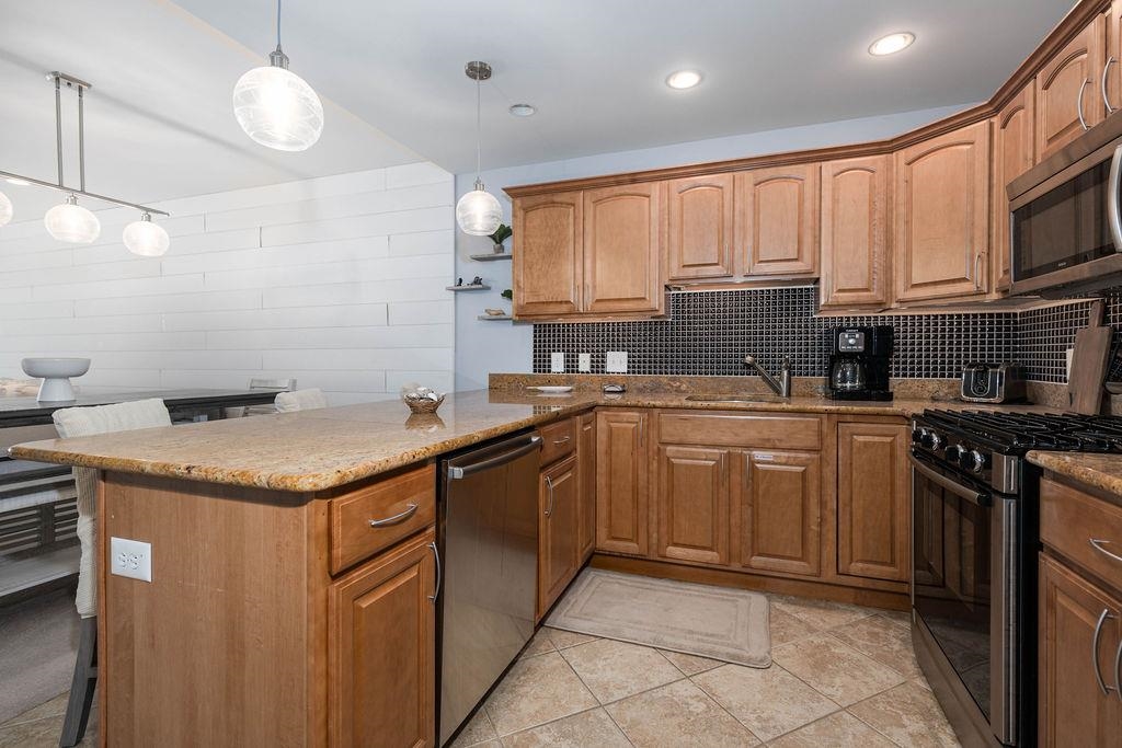 415 East Heather Road, Unit 106 Wildwood Crest, NJ 08260 - Photo 4 of 41 a kitchen with stainless steel appliances granite countertop a sink and a stove