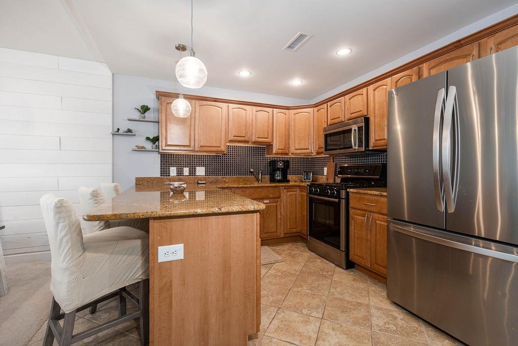 415 East Heather Road, Unit 106 Wildwood Crest, NJ 08260 - Photo 5 of 41 a kitchen with kitchen island granite countertop a sink appliances cabinets and furniture