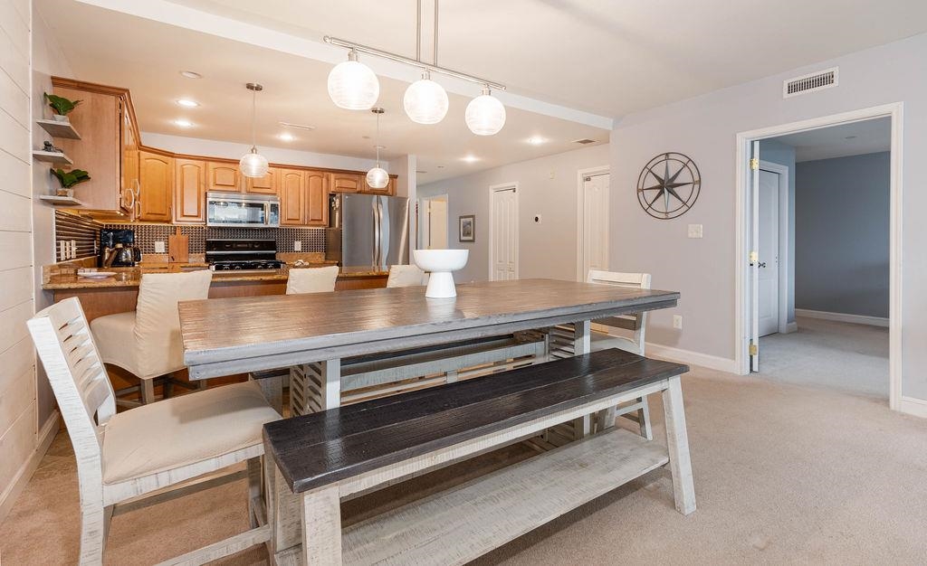 415 East Heather Road, Unit 106 Wildwood Crest, NJ 08260 - Photo 8 of 41 a kitchen with a table chairs and stove