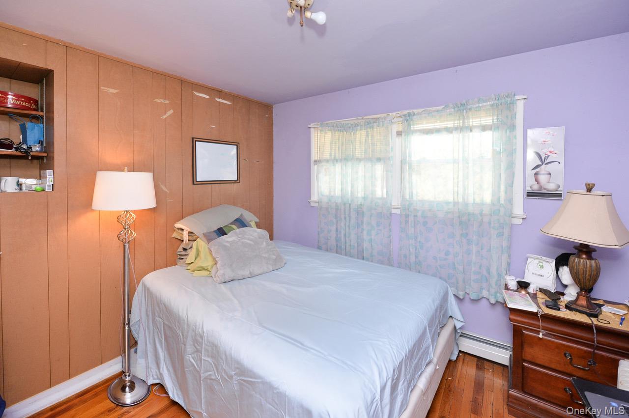 7 South Oak Street Spring Valley, NY 10977 - Photo 11 of 24 a bedroom with a bed and a lamp on dresser