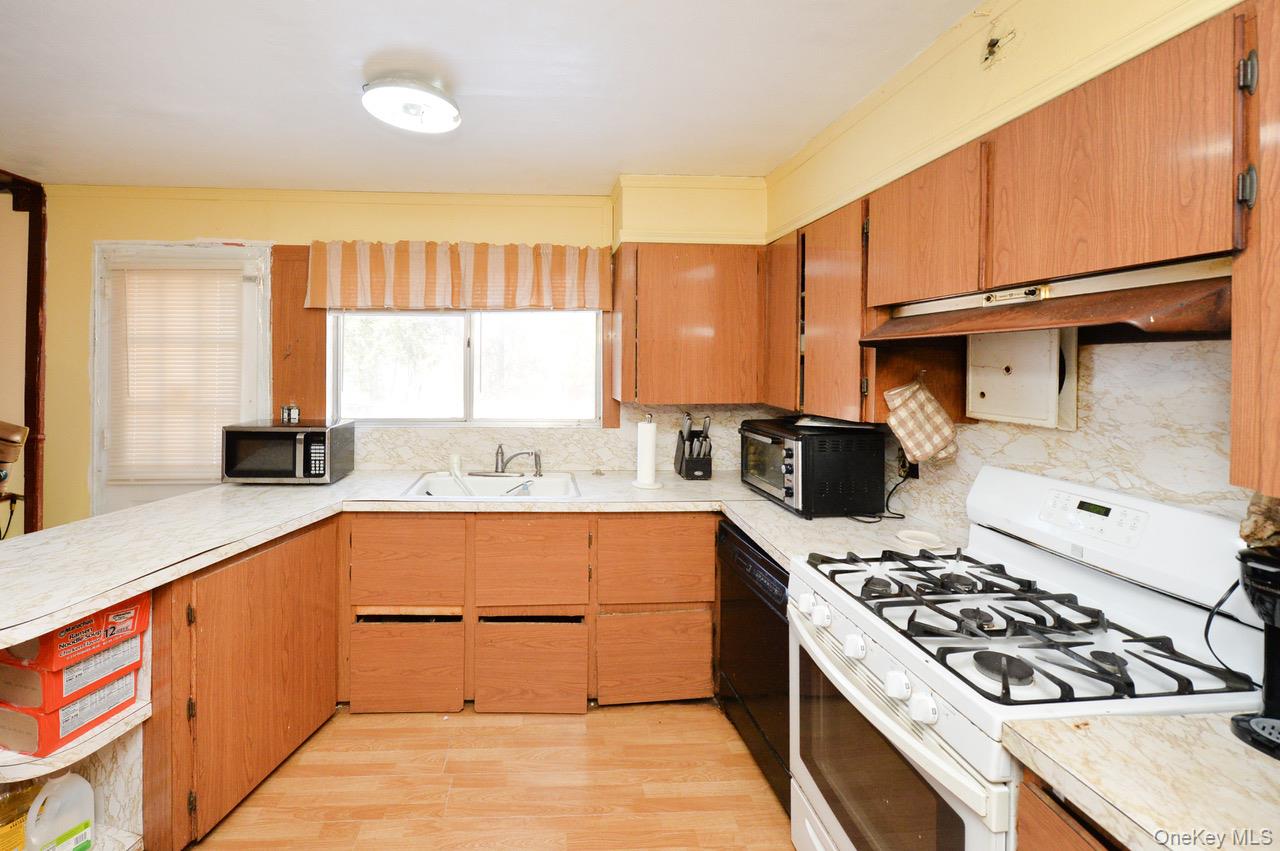 7 South Oak Street Spring Valley, NY 10977 - Photo 19 of 24 a kitchen with a stove a sink and a refrigerator