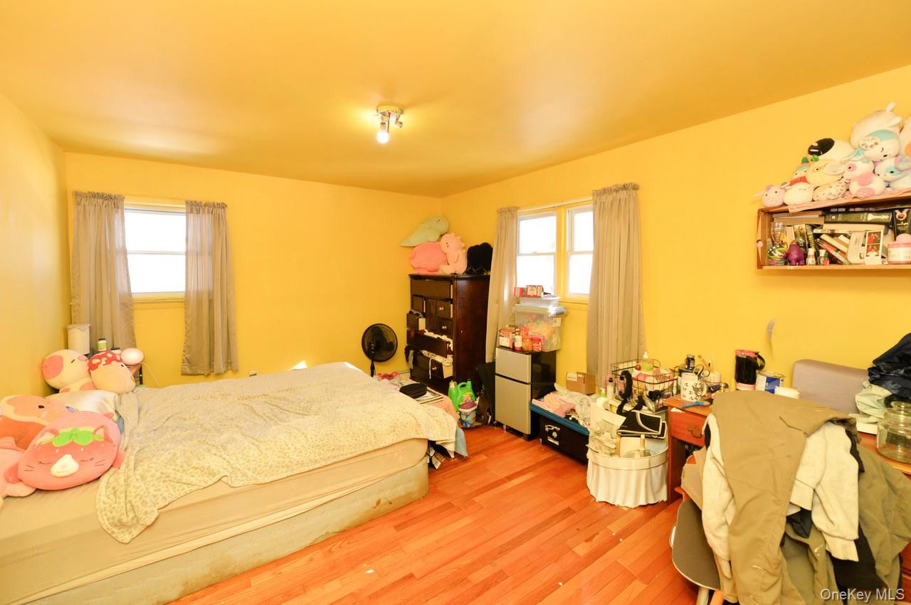 7 South Oak Street Spring Valley, NY 10977 - Photo 9 of 24 a bedroom with a bed and large windows