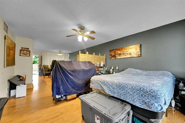 a bedroom with bed a mirror and a flat tv screen on dresser