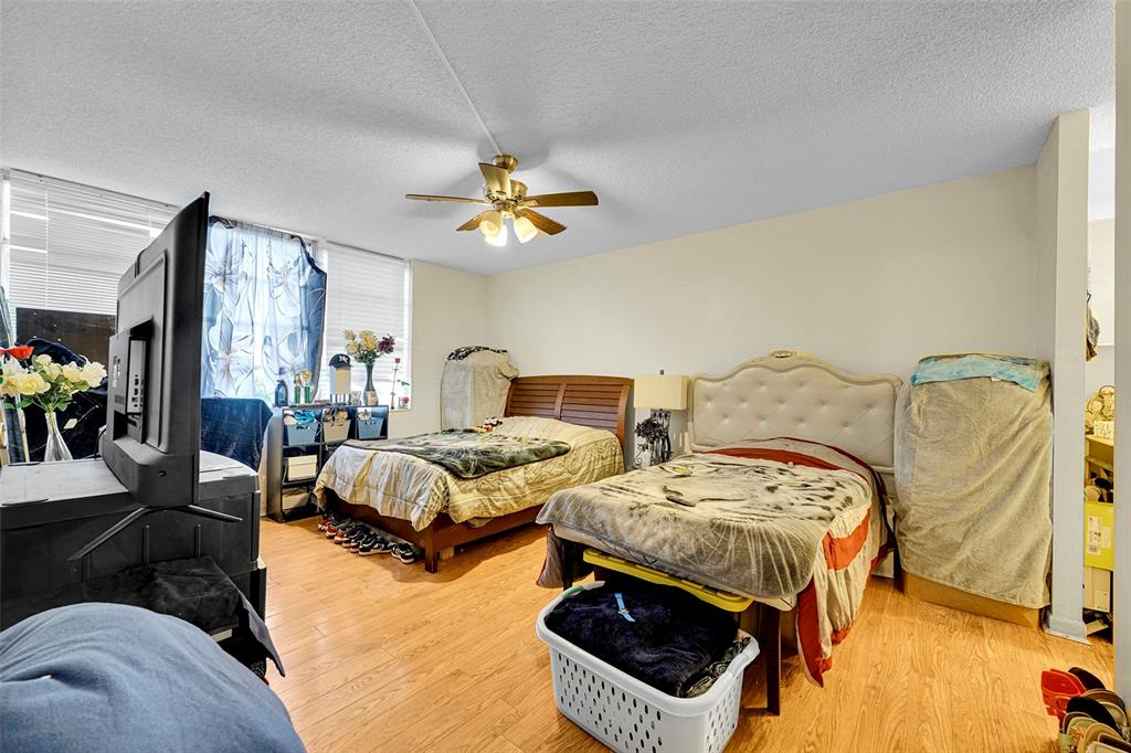 7041 Environ Boulevard, Unit 326 Lauderhill, FL 33319 - Photo 14 of 44 a bedroom with two beds and a chandelier