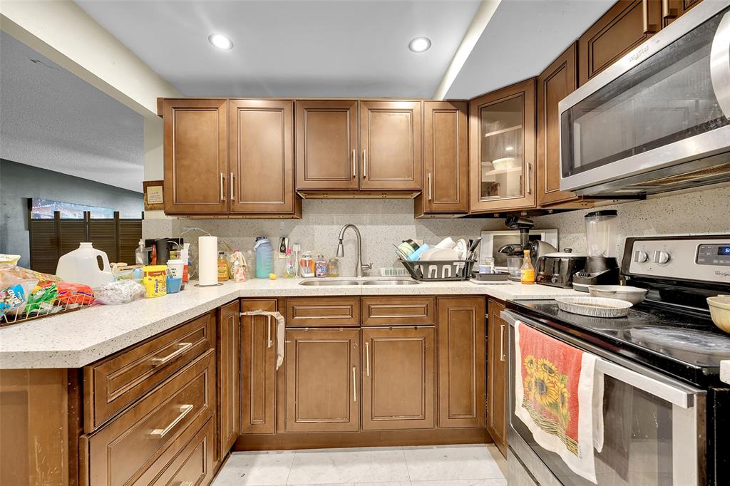 7041 Environ Boulevard, Unit 326 Lauderhill, FL 33319 - Photo 2 of 44 a kitchen with stainless steel appliances granite countertop a sink stove and cabinets