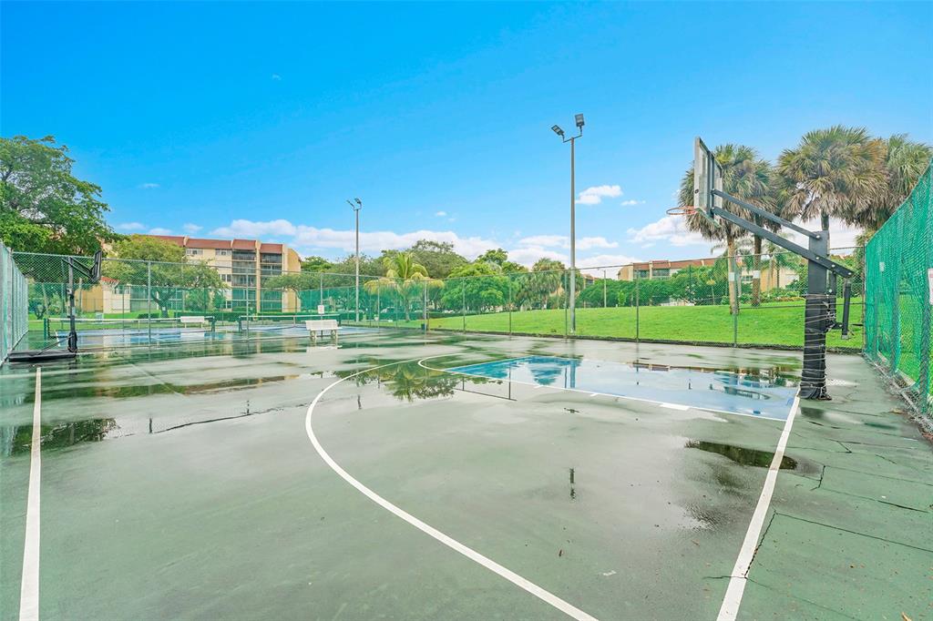 7041 Environ Boulevard, Unit 326 Lauderhill, FL 33319 - Photo 40 of 44 a view of a swimming pool with a yard and trees in the background