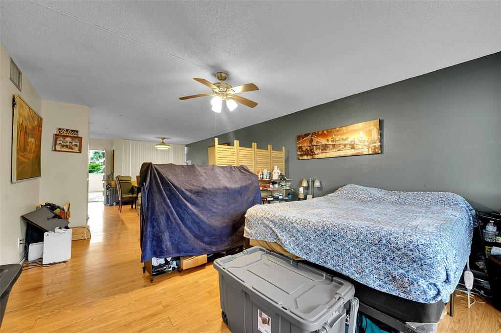 7041 Environ Boulevard, Unit 326 Lauderhill, FL 33319 - Photo 6 of 44 a bed room with a bed and a chandelier