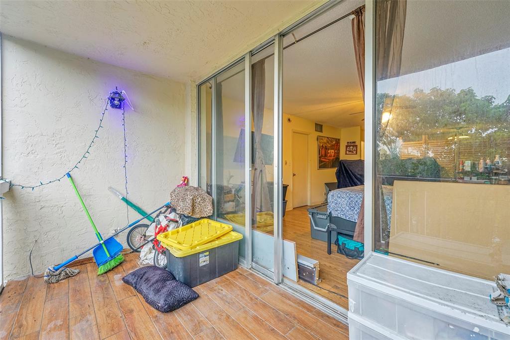 7041 Environ Boulevard, Unit 326 Lauderhill, FL 33319 - Photo 7 of 44 a living room with a rug floor to ceiling window and a wooden floor