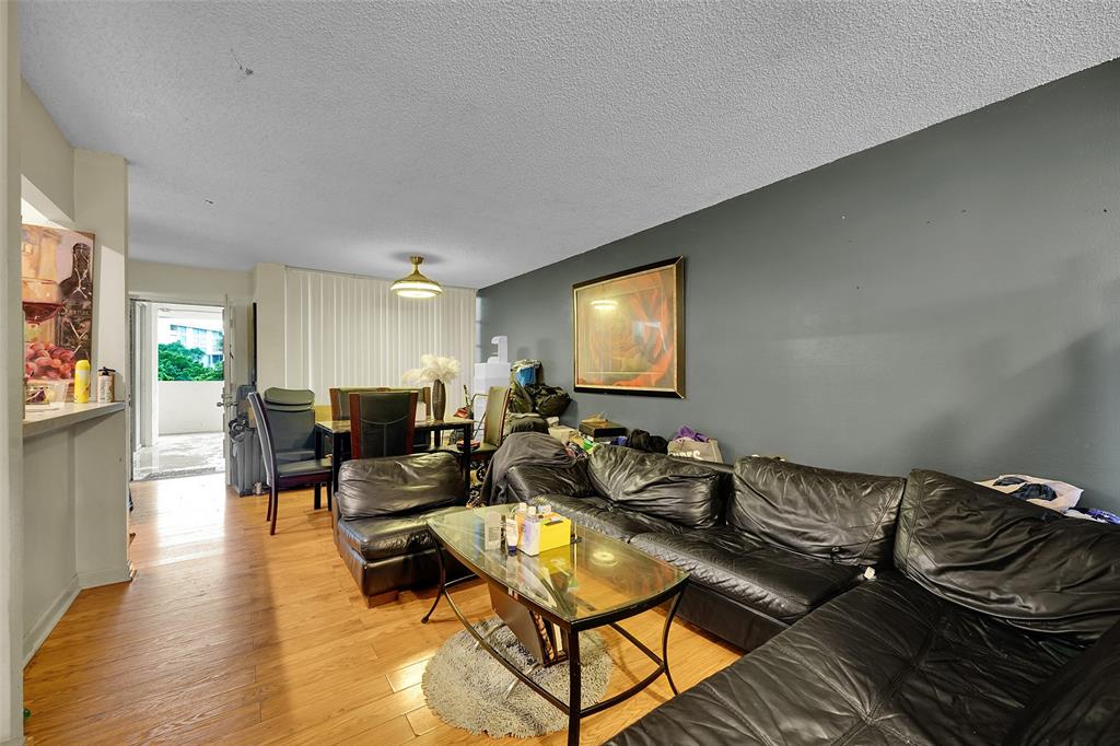 7041 Environ Boulevard, Unit 326 Lauderhill, FL 33319 - Photo 9 of 44 a living room with furniture and a flat screen tv
