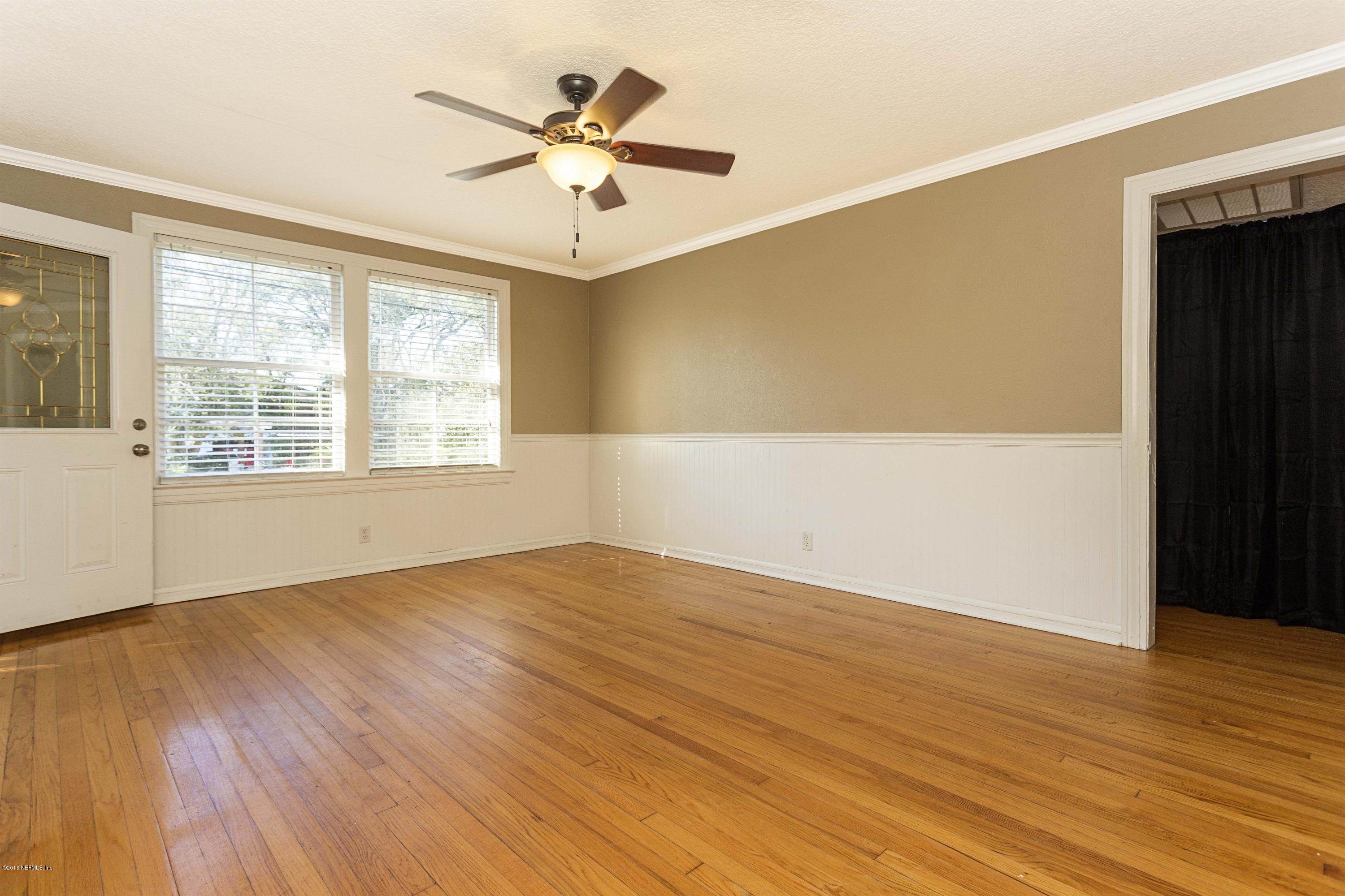 2309 Somerset Road Jacksonville, FL 32210 - Photo 5 of 21 an empty room with wooden floor and windows
