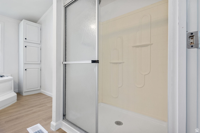 2600 North Hill Field Road, Unit 86 Layton, UT 84041 - Photo 14 of 25 Bathroom with light wood-style flooring, a shower stall, and ornamental molding