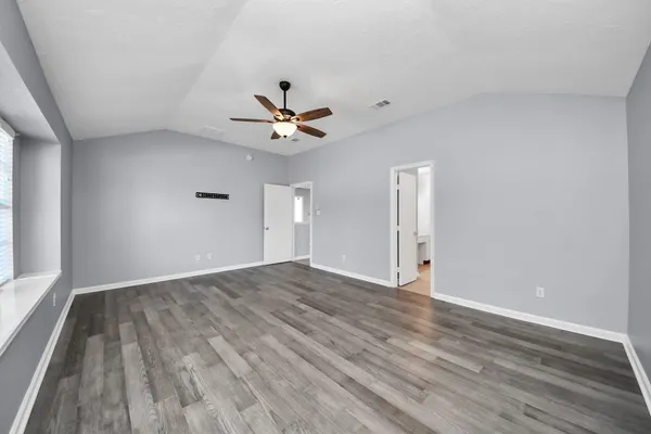 a view of empty room with wooden floor