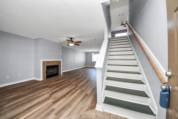 a view of a livingroom with wooden floor and a ceiling fan