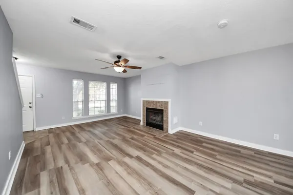 a view of an empty room with window and fire place
