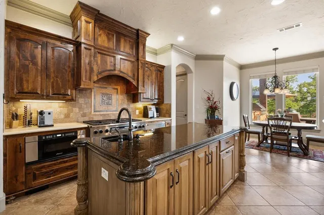 a kitchen with stainless steel appliances granite countertop a sink stove and cabinets