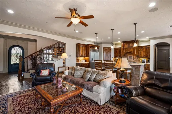 a living room with furniture kitchen view and a chandelier