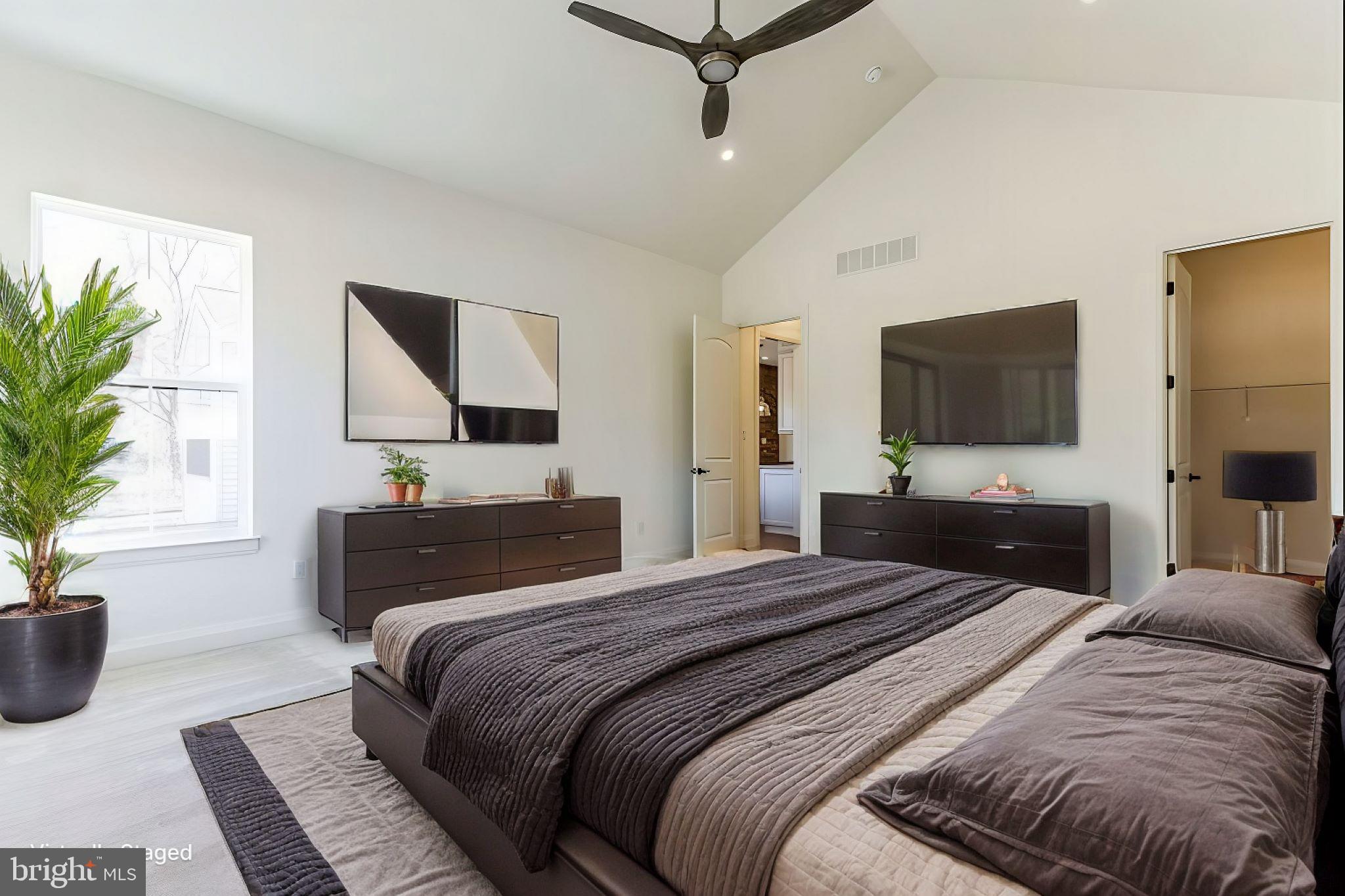 1487 Bunker Hill Road Middletown, DE 19709 - Photo 15 of 33 a bedroom with a large bed a flat tv screen and a potted plant