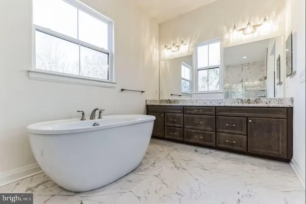 a bathroom with a tub sink and mirror