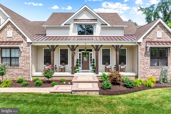 a front view of a house with a yard and potted plants