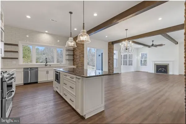 a kitchen with stainless steel appliances granite countertop wooden floors and white cabinets
