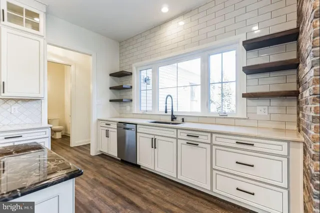 a kitchen with granite countertop white cabinets and white appliances