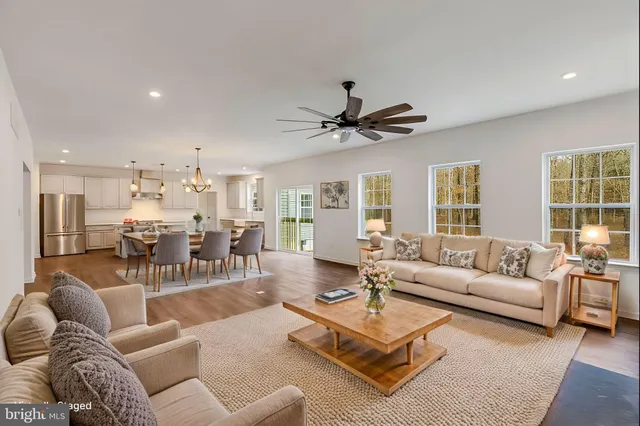 a living room with furniture kitchen view and a large window