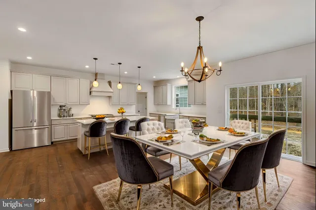 a dining room filled chandelier and wooden floor