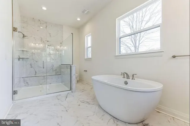 a white bath tub sitting next to a shower