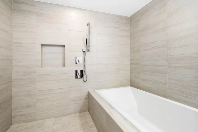 a spacious bedroom with a bed and glass window