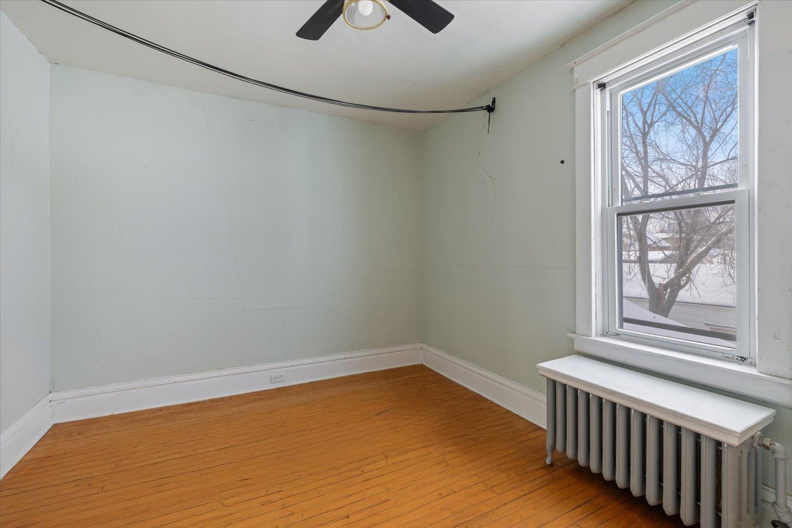 217 3rd Avenue Northwest Chisholm, MN 55719 - Photo 15 of 47 Empty room with radiator heating unit and hardwood / wood-style floors