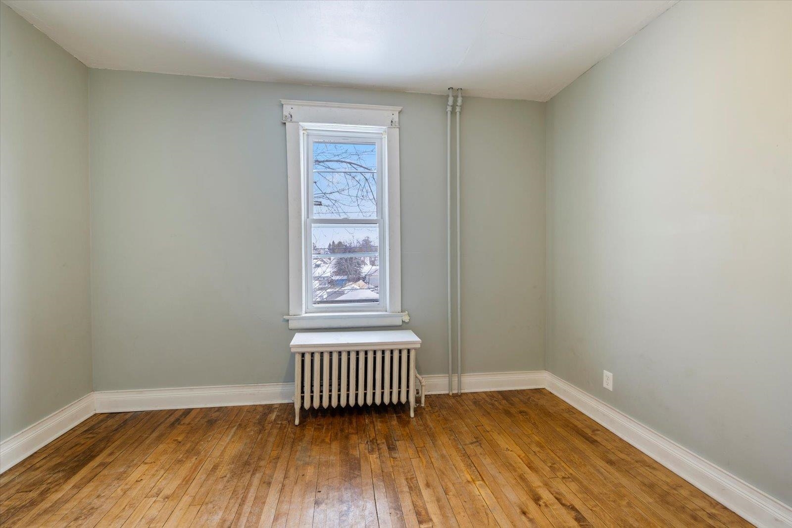 217 3rd Avenue Northwest Chisholm, MN 55719 - Photo 25 of 47 Empty room with radiator and hardwood / wood-style floors