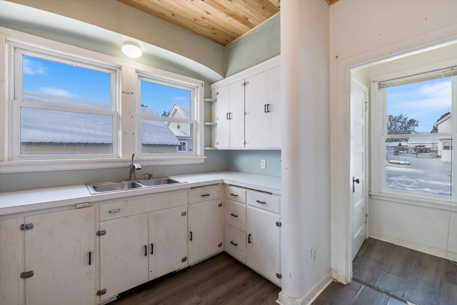 217 3rd Avenue Northwest Chisholm, MN 55719 - Photo 9 of 47 Kitchen with light countertops, dark wood-style flooring, open shelves, white cabinets, and wood ceiling