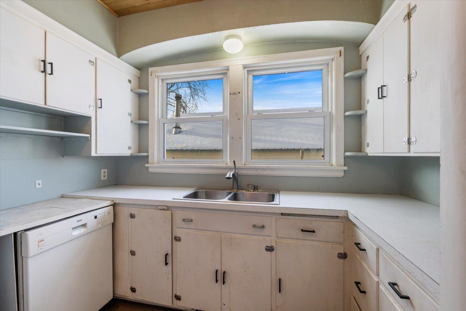 217 3rd Avenue Northwest Chisholm, MN 55719 - Photo 10 of 47 Kitchen featuring open shelves, light countertops, dishwasher, and white cabinetry