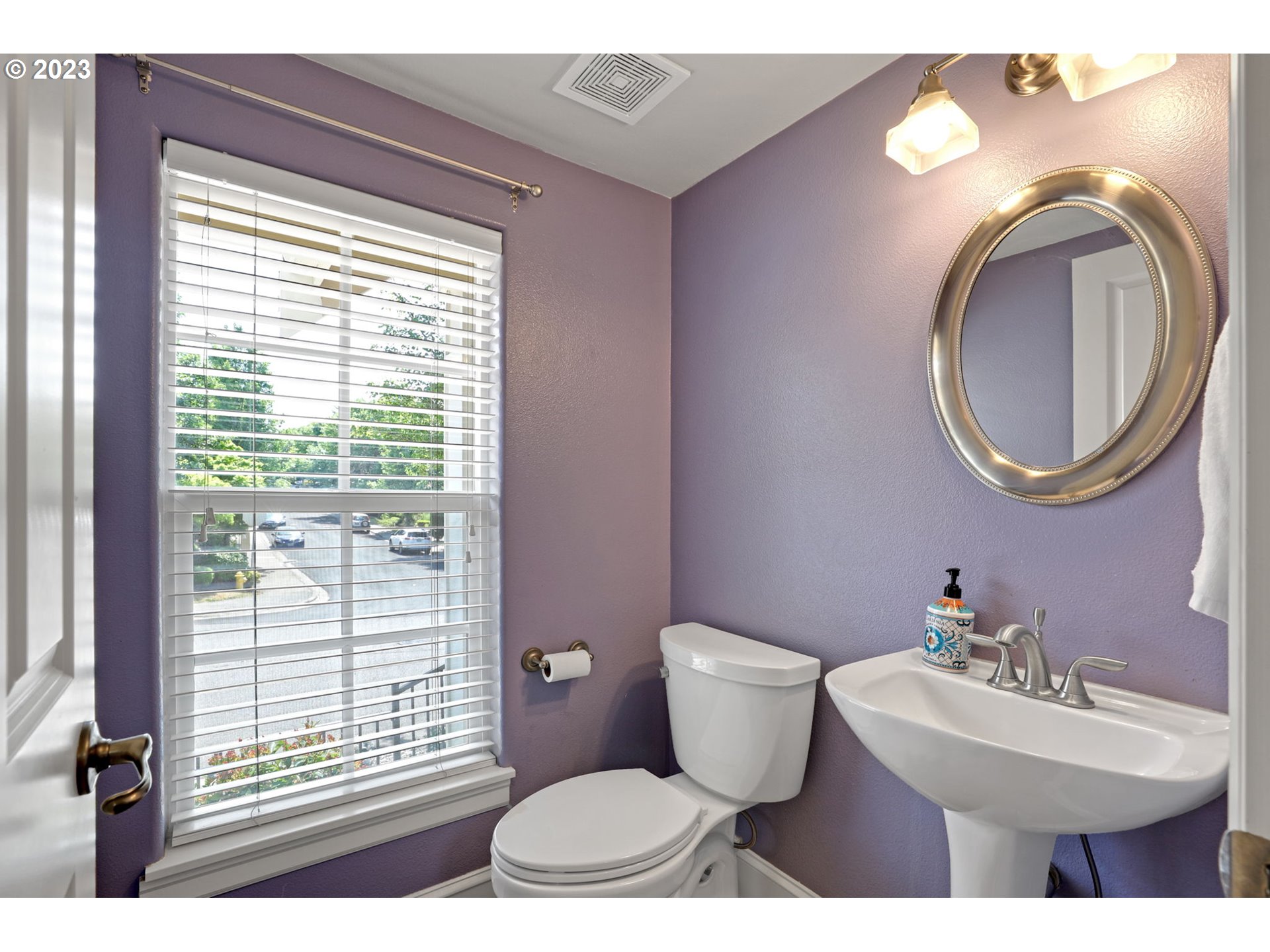 12799 Northwest Forest Spring Lane Portland, OR 97229 - Photo 14 of 30 a bathroom with a toilet a sink a mirror and a window