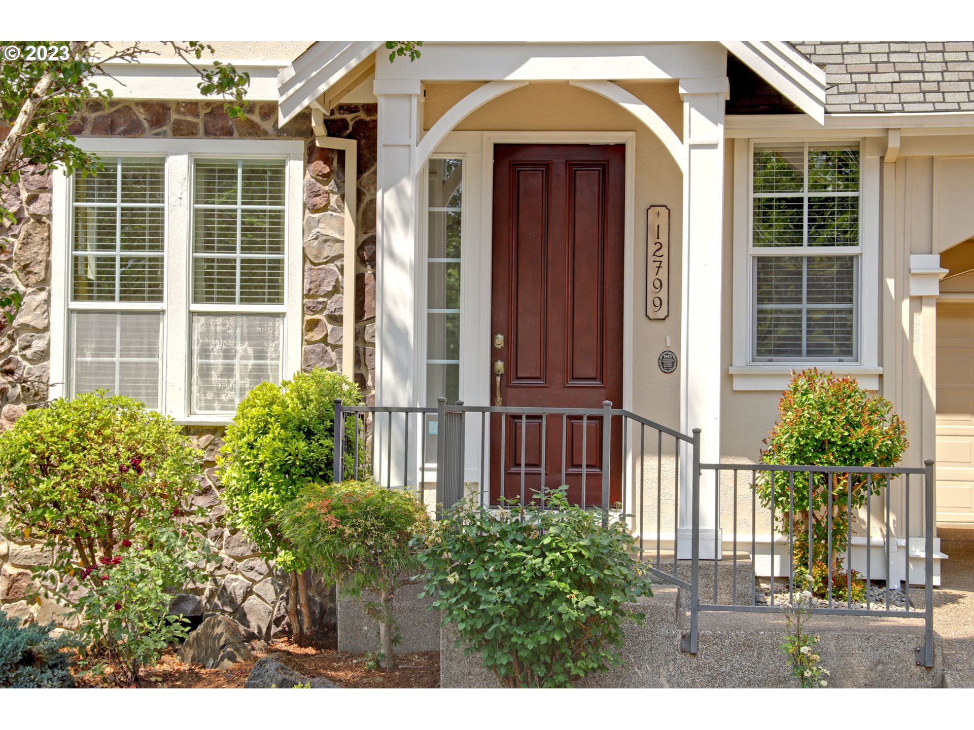 12799 Northwest Forest Spring Lane Portland, OR 97229 - Photo 2 of 30 a view of a house with a small yard and plants