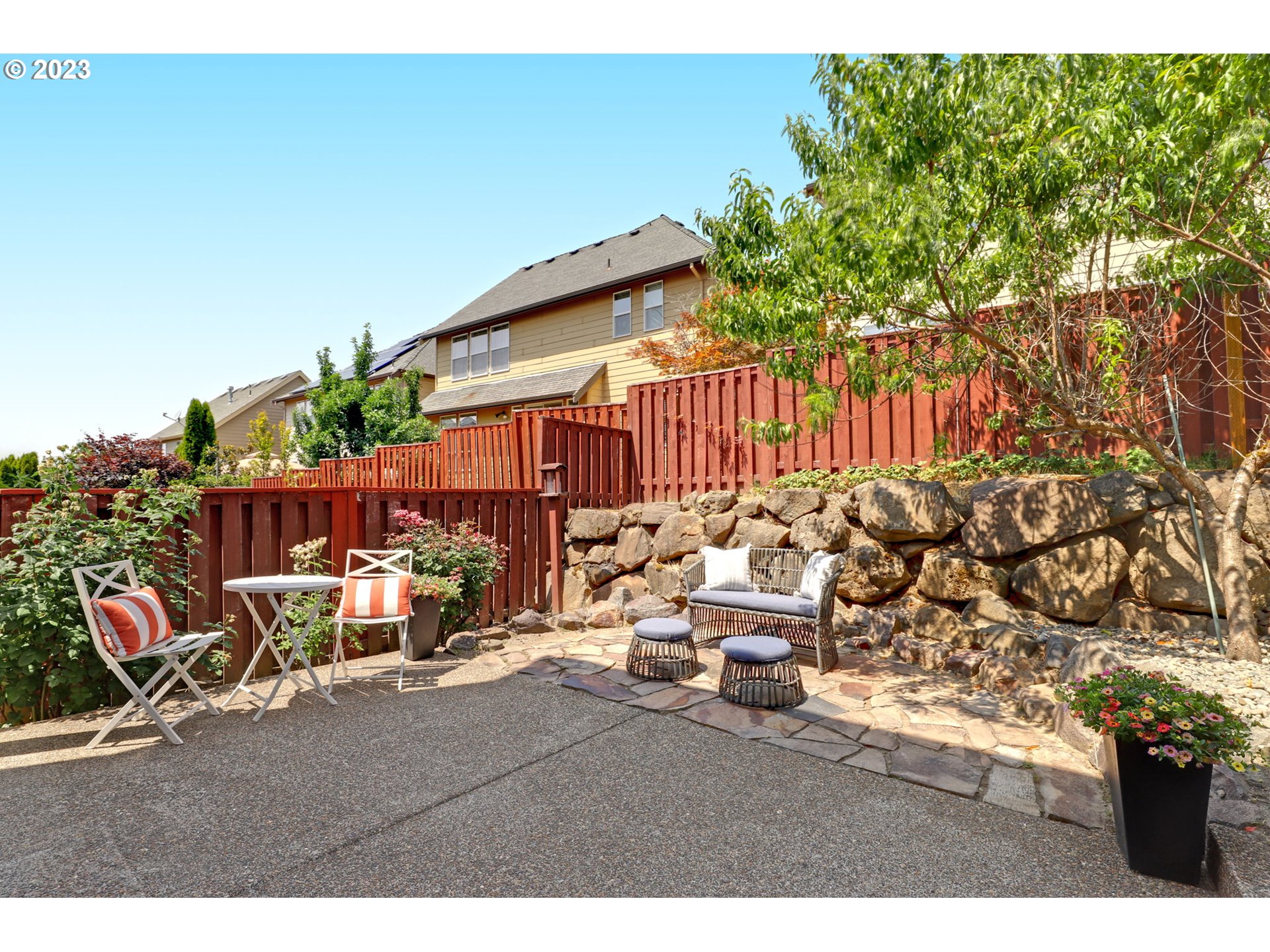 12799 Northwest Forest Spring Lane Portland, OR 97229 - Photo 27 of 30 a backyard of a house with table and chairs with wooden fence