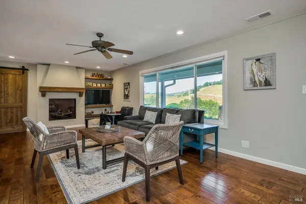 a view of a kitchen with kitchen island a stove a wooden floor and a dining table